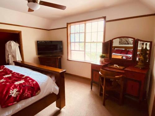a bedroom with a bed and a desk and a mirror at Paradise Lodge - Blue Mountains Wonderland in Linden