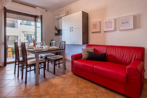 a living room with a red couch and a table at LE TERRAZZE apartments in Alghero