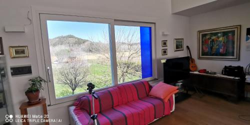 - un salon avec un canapé et une grande fenêtre dans l'établissement Casa Anna, à San Giovanni a Corazzano 