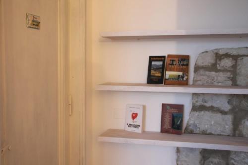 uma estante de livros com livros ao lado de uma porta em La casa di Elvira2 em Castelnuovo Berardenga