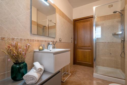 a bathroom with a sink and a shower and a mirror at LE TERRAZZE apartments in Alghero