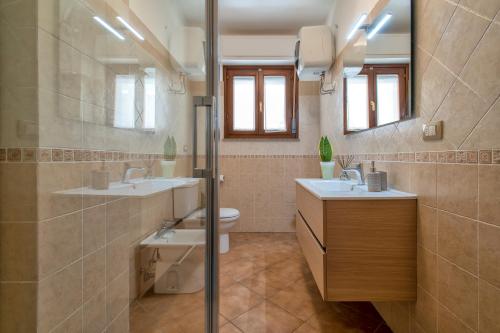 a bathroom with a toilet and two sinks and a shower at LE TERRAZZE apartments in Alghero