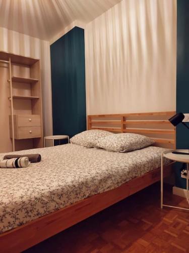 une chambre avec un lit avec une tête de lit en bois dans l'établissement Grande maison tout confort avec extérieur centre, à Rennes