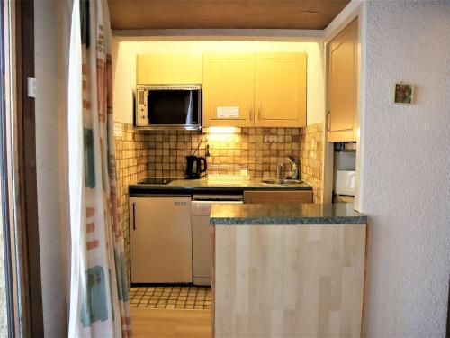 a kitchen with yellow cabinets and a counter top at Appartement Auris, 2 pièces, 4 personnes - FR-1-297-65 in Auris