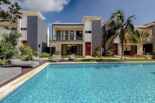 a swimming pool in front of a house at Spacious Condo, beautiful pool, Wi-Fi - Casa Kaanal 104 in Tulum