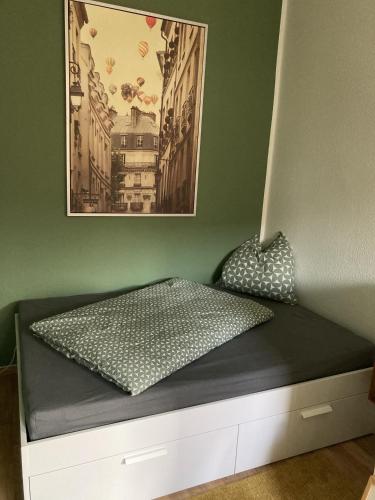 a bed in a room with a picture on the wall at Sonniges Altstadt Nest in Magdeburg