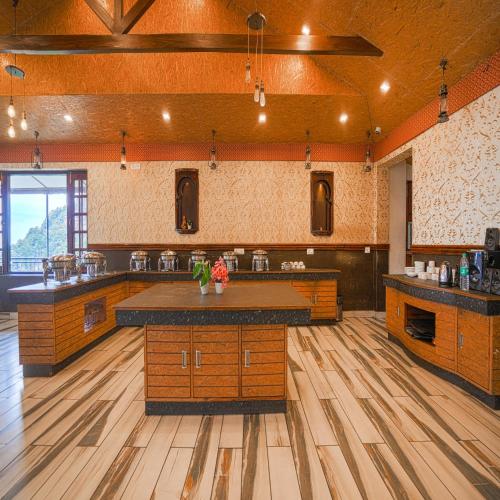a large kitchen with wooden floors and a large island at Pax Hotel Ark 150 meters from Mall Road in Dalhousie