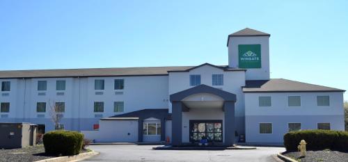 a large white building with a clock tower on top at Wingate by Wyndham Bel Air I-95 Exit 77A - APG Area in Edgewood
