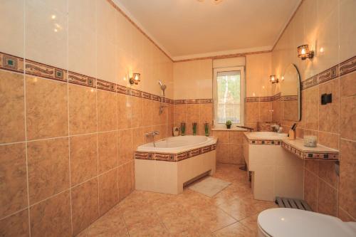 a bathroom with two sinks and a tub and a toilet at Kwintesencja Natury in Stobnicko