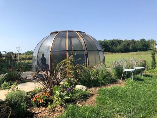 a greenhouse in the middle of a garden at Gîte des Contes in Madiran