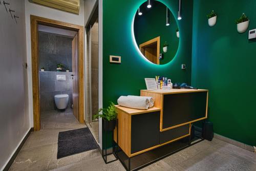 a bathroom with a green wall and a mirror at Room4stars in Otruševec