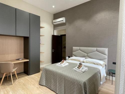 um quarto com uma cama, uma mesa e uma cadeira em Napoli Mariana Luxury em Nápoles