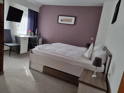 a bedroom with a bed and a desk in it at Berghotel-Willingen in Willingen