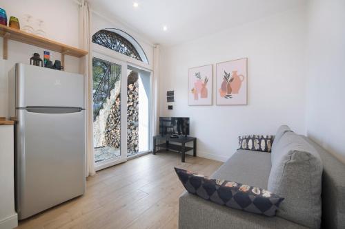 - un salon avec un canapé et un réfrigérateur dans l'établissement Incantevole Veranda Panoramica, à Albenga