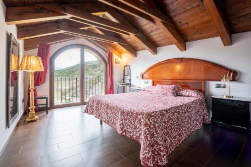 a bedroom with a bed and a large window at Casa Dieste Apartamentos Turísticos en Boltaña in Boltaña