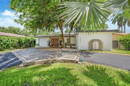 a house with a palm tree in front of a driveway at Hollywood Beach Exquisite 4-bed 3-bath Villa in Hollywood