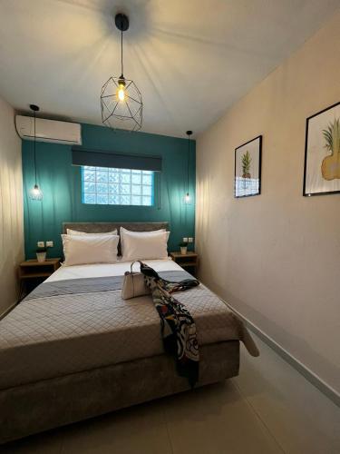 a bedroom with a bed with a blue wall at Veni's Apartments in Potos