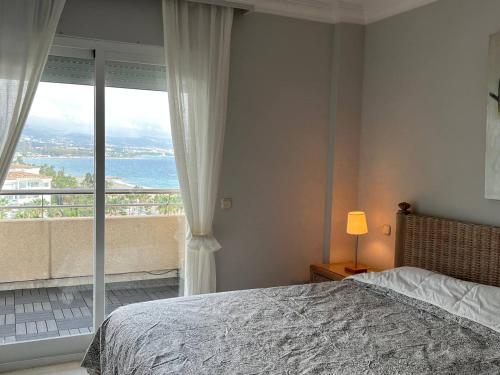 1 dormitorio con cama y vistas al océano en Marbella Marina Banus luxurious apartment, Sea and mountain views, en Marbella