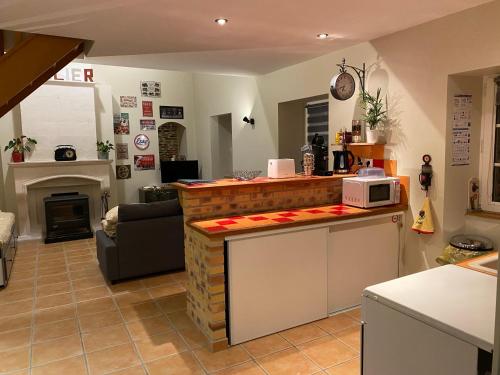 - une cuisine avec un comptoir et un four micro-ondes dans l'établissement Gite " La petite maison", à Livry