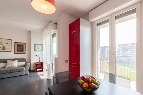 a living room with a table with a bowl of fruit at Sky Home Santa Giulia in Milan
