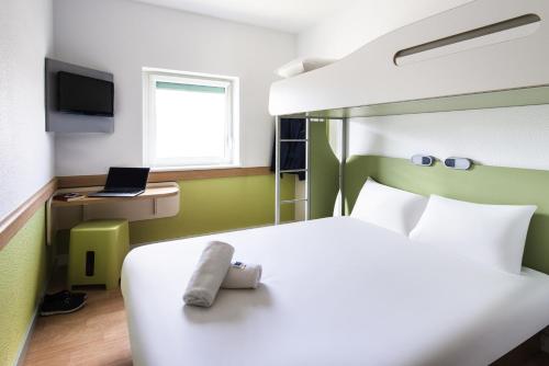 a bedroom with a bed with a stuffed animal on it at ibis budget Manchester Salford Quays in Manchester