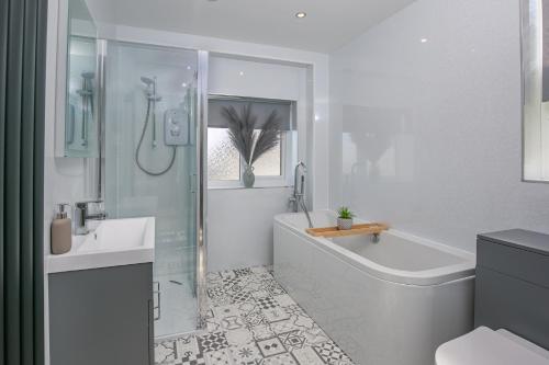 ein weißes Badezimmer mit einer Badewanne und einem Waschbecken in der Unterkunft 412 Roman Bank in Ingoldmells