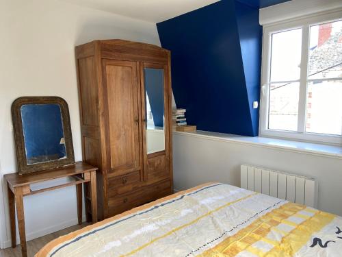 Schlafzimmer mit einem Bett, einer Kommode und einem Spiegel in der Unterkunft Val-André vue sur mer in Pléneuf-Val-André