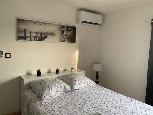 sypialnia z łóżkiem i zdjęciem na ścianie w obiekcie Chez Tonton David 972 w mieście Fort-de-France