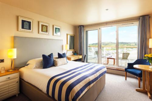 a hotel room with a bed and a large window at St Brides Spa Hotel & Village Apartments in Saundersfoot