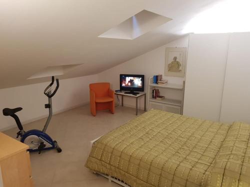 a bedroom with a bed and a chair and a television at La Mansarda di Corso Umberto in Pescara