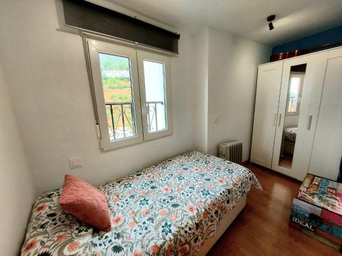 1 dormitorio con 1 cama y 2 ventanas en El Molinillo en Ojén