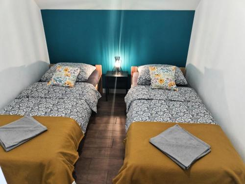 Duas camas num quarto com paredes azuis em Apartamenty Jodłowa - bilard - bawialnia - królikarnia em Krajno-Zagórze
