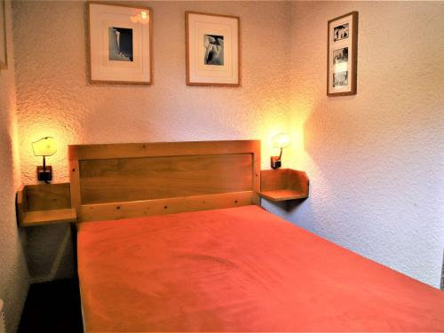 ein Schlafzimmer mit einem roten Bett mit zwei Lampen in der Unterkunft Appartement Auris, 2 pièces, 4 personnes - FR-1-297-133 in Auris