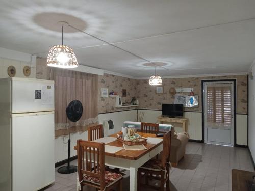 a kitchen and dining room with a table and a refrigerator at La Paz in Lobos