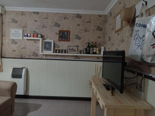 a room with a desk with a television on a counter at La Paz in Lobos