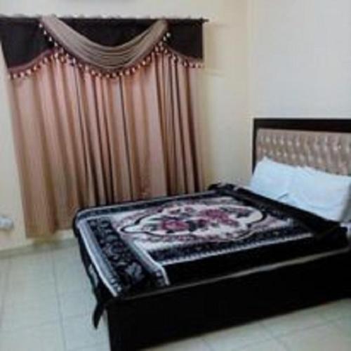 a bedroom with a bed with a black frame and curtains at Hotel Sky Inn in Rawalpindi
