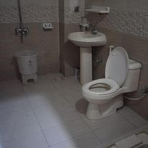 a bathroom with a toilet and a sink at Hotel Sky Inn in Rawalpindi