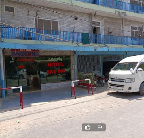 a white van parked in front of a building at Hotel Sky Inn in Rawalpindi