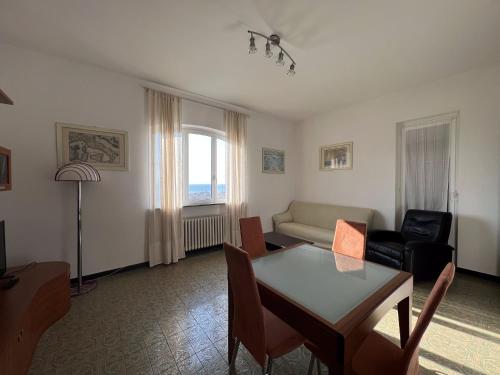 a living room with a table and a couch at Appartamento vista mare in villa in Spotorno