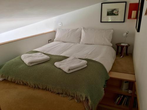 sypialnia z łóżkiem z dwoma ręcznikami w obiekcie Unique Artists studio with a private garden. w mieście Pewsey