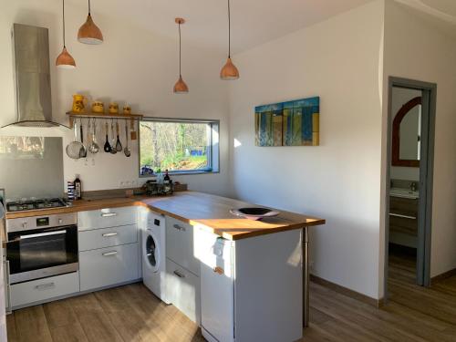 a kitchen with white cabinets and a wooden counter top at Coutillard in Parisot-Tarn-et-Garonne
