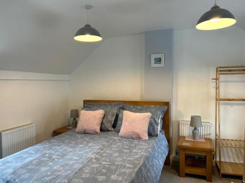 a bedroom with a bed with two pink pillows at Pendragon in Penzance