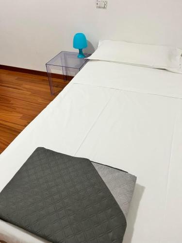 a bed with a glass table and a blue bottle on it at Nuovo appartamento "Lux" in San Benedetto del Tronto