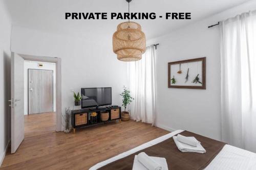 Pula City Apartment with private parking FREE في بولا: غرفة بيضاء مع سرير وتلفزيون