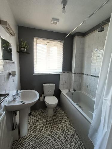 a bathroom with a toilet and a tub and a sink at Trevithick Gardens, No 47. in Merthyr Tydfil