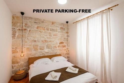 Pula City Apartment with private parking FREE في بولا: غرفة نوم عليها سرير وفوط بيضاء