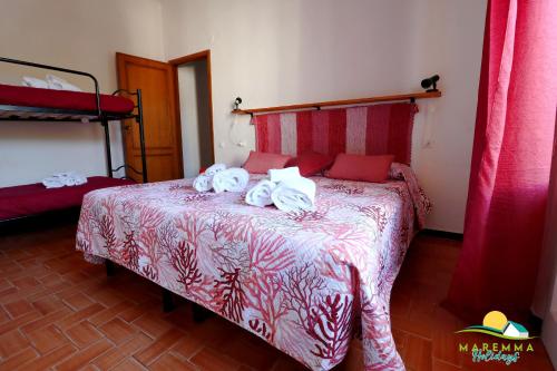1 dormitorio con 1 cama con toallas en Maremma Holidays : Trasimeno Apartment, en Follonica