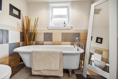 a bathroom with a tub and a toilet at A Peaceful Suite Stay in Brentwood Bay