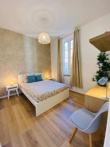 une chambre avec un lit, une table et une chaise dans l'établissement Les Deux Anges, à Rouen