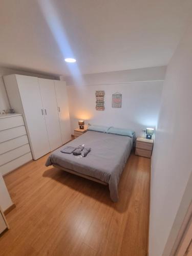 a bedroom with a bed and a wooden floor at Playa 130m in Málaga
